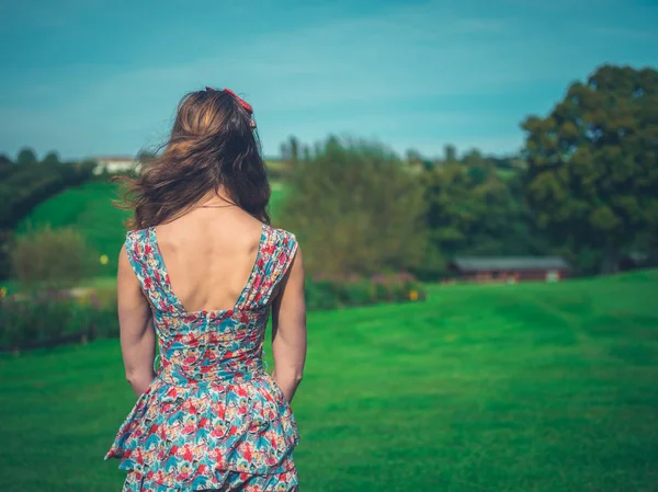 Молодая женщина в платье на зеленой лужайке — стоковое фото