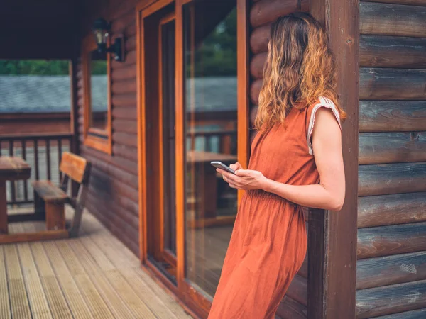 Frau benutzt Smartphone auf Veranda — Stockfoto