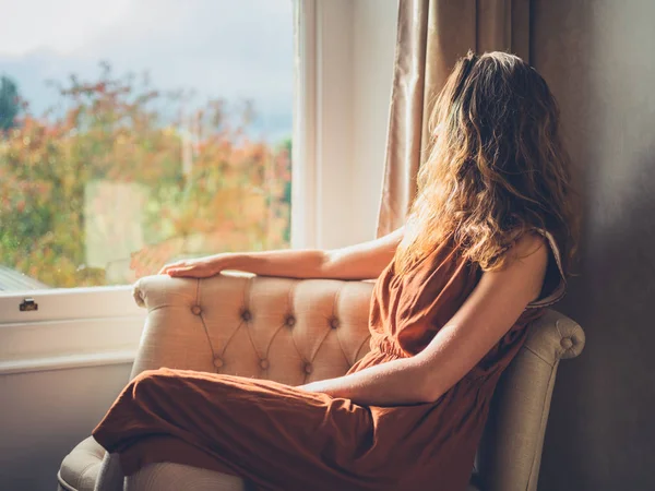 Mladá žena relaxační oknem — Stock fotografie