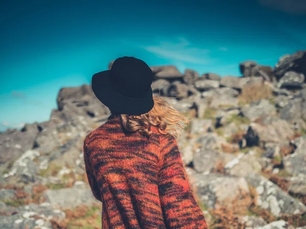 Νεαρή γυναίκα με καπέλο περπάτημα στην έρημο — Φωτογραφία Αρχείου