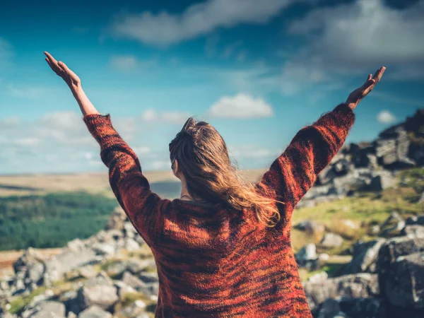 Jonge vrouw verhogen haar armen in de wildernis — Stockfoto