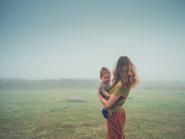 Madre con el bebé en la niebla en el páramo —  Fotos de Stock