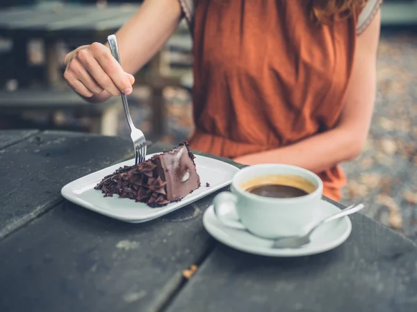 Jovem mulher comer bolo e beber café — Fotografia de Stock