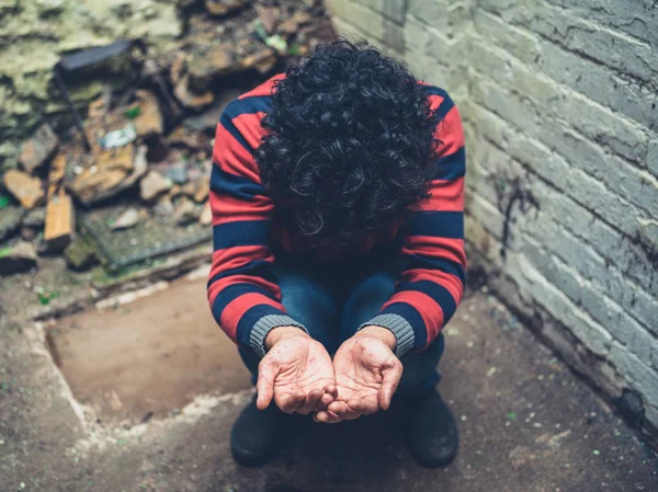 Jonge man met uitslag op handen bedelen — Stockfoto