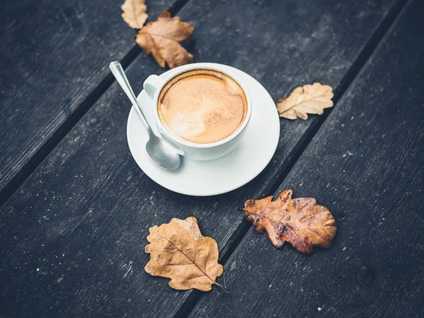 Cup of coffee on table with leaves in autumn — Stock Photo, Image