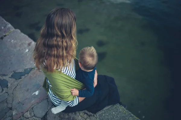 Madre con el bebé en honda por el agua — Foto de Stock