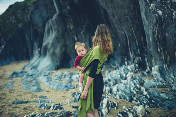 Mother with baby by rocks — Stock Photo, Image
