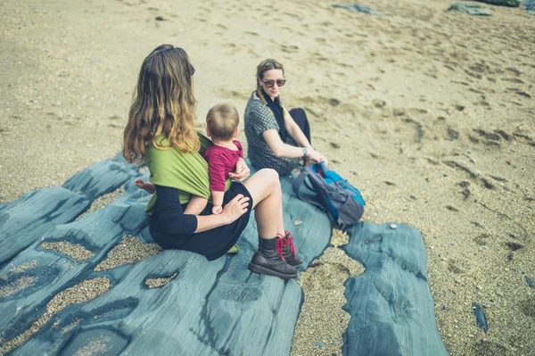 Deux femmes avec un bébé assis sur la plage — Photo
