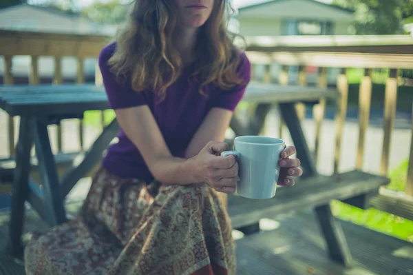 Mujer bebiendo de la taza en el parque de remolques — Foto de Stock