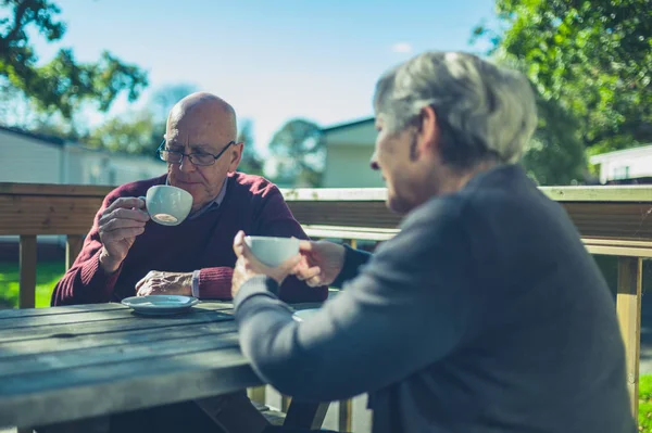 Senior couple drinking coffee in caravan park