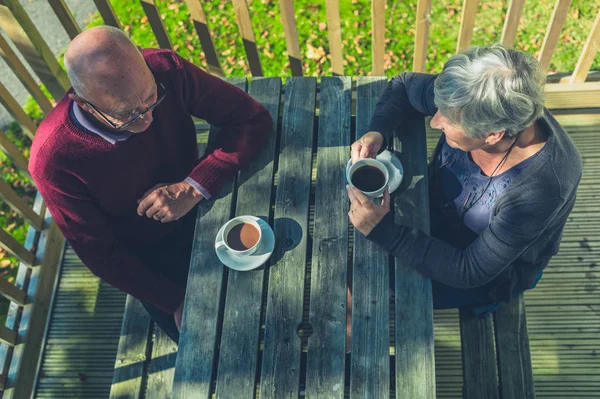 Senior couple drinking coffee in caravan park