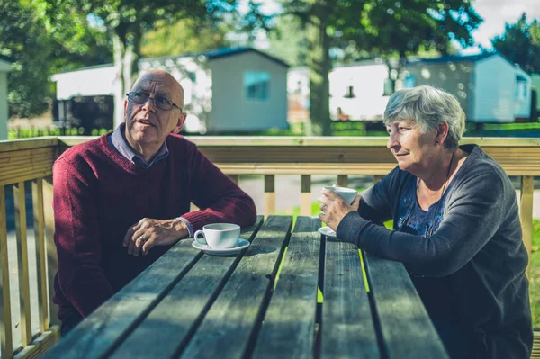Senior couple drinking coffee in caravan park