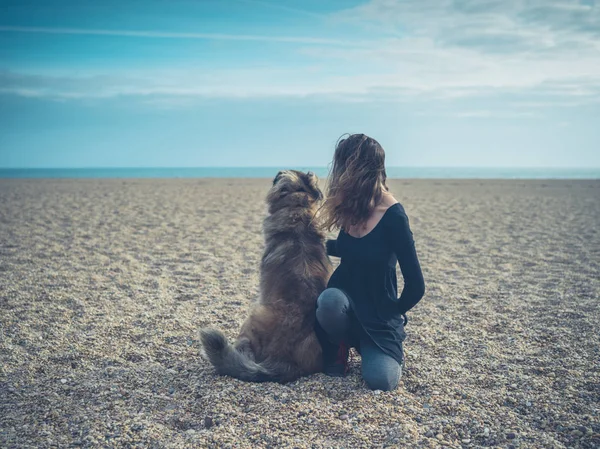 Jovem mulher na praia com cão gigante — Fotografia de Stock