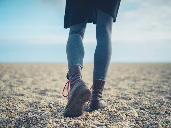 Benen på en kvinna som promenerar på stranden i höst — Stockfoto