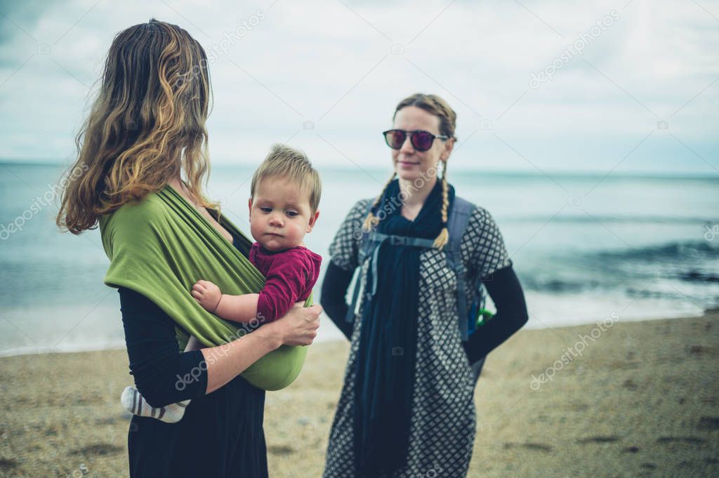 Two young women with a baby on the beach