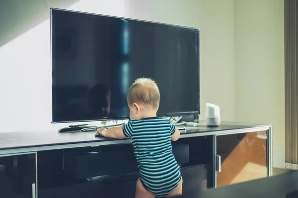 Baby przelotową na meble przez Tv — Zdjęcie stockowe