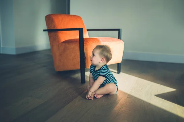 Lindo bebé sentado junto a una silla a la luz del sol —  Fotos de Stock