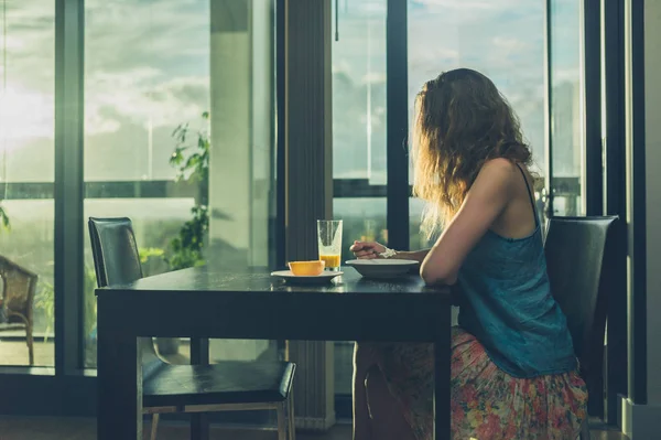 Mujer joven desayunando junto a la ventana de la ciudad —  Fotos de Stock