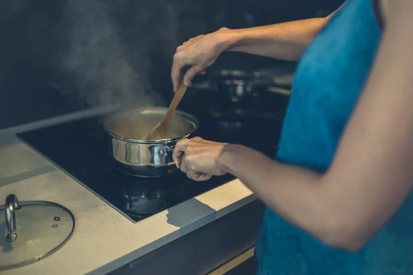 Ung kvinna matlagning i köket — Stockfoto