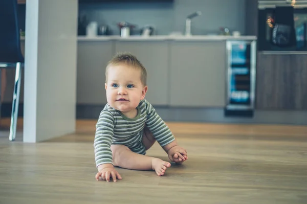 Pequeño bebé en piso de cocina — Foto de Stock