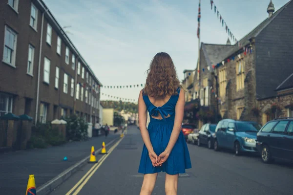 Vrouw in blauwe jurk permanent in de straat — Stockfoto