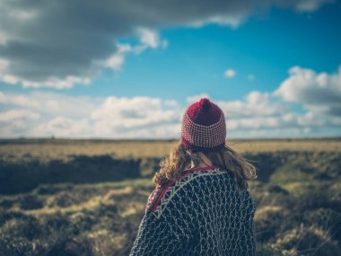 Genç bir kadın kışın moor üzerinde yürüyor