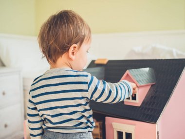 Küçük çocuk stereotipler ve sosyal olarak empoze beklentileri olan bir büyük pembe bebek ev ve having a büyük zaman oynayarak busting olduğunu emin şirin bir cinsiyet