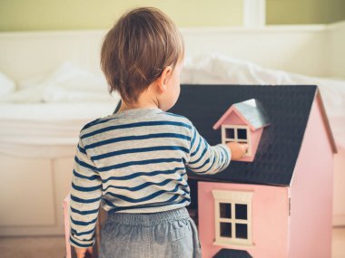 Küçük çocuk stereotipler ve sosyal olarak empoze beklentileri olan bir büyük pembe bebek ev ve having a büyük zaman oynayarak busting olduğunu emin şirin bir cinsiyet