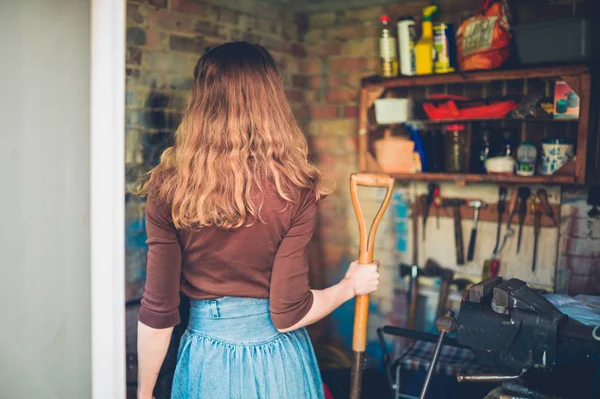 Una Joven Está Pie Cobertizo Sosteniendo Una Pala — Foto de Stock