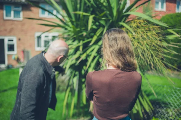 Uomo Anziano Una Giovane Donna Sono Giardino Che Indica Una — Foto Stock