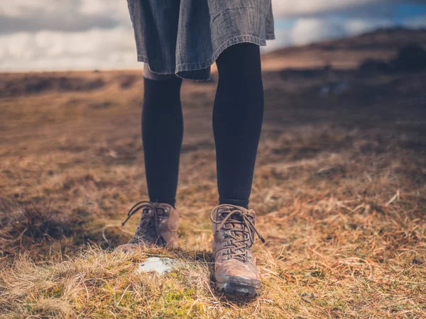 The legs and feet of a young woman hiking on the moor