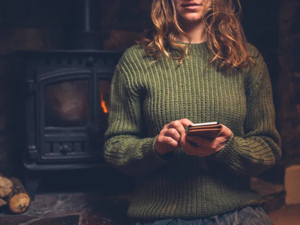 Young Woman Using Her Smart Phone Fire Log Burner — Stock Photo, Image