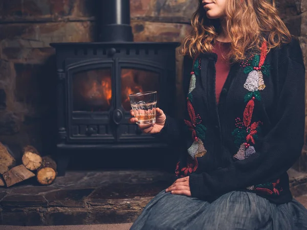 Young Woman Wearing Christmas Jumper Sitting Fire Drink Her Hand — Stock Photo, Image