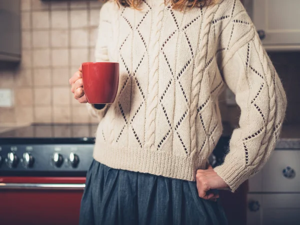 Una Joven Está Parada Junto Estufa Con Una Taza —  Fotos de Stock