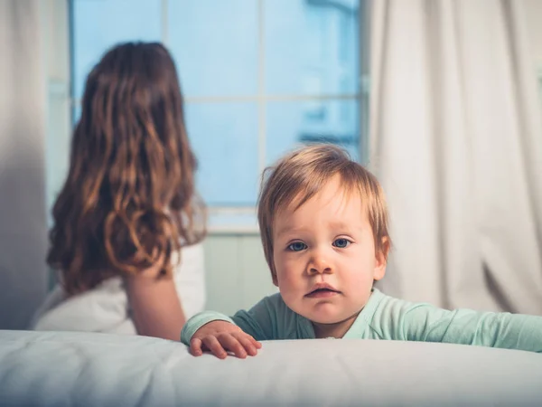 Menino Bonito Está Olhando Para Câmera Com Sua Mãe Fundo — Fotografia de Stock