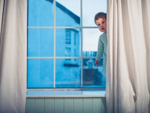 Een Schattige Kleine Jongen Verstopt Achter Het Gordijn Ochtend — Stockfoto