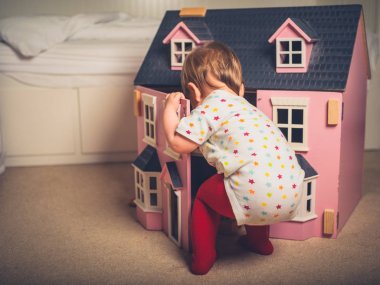 Tatlı küçük bebek bir oyuncak ev ile oynuyor