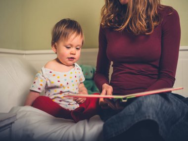 Genç bir anne küçük oğlu masal okuyor