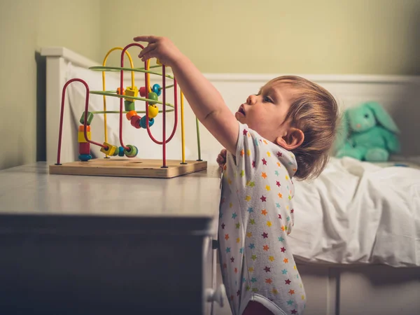 Ein Kleiner Junge Spielt Mit Einem Spielzeug Neben Seinem Bett — Stockfoto
