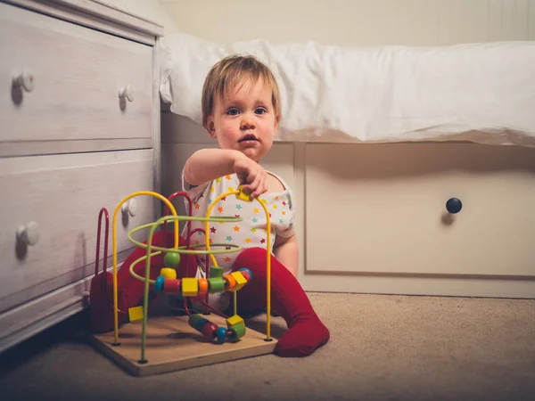 Ein Kleiner Junge Spielt Mit Einem Spielzeug Neben Seinem Bett — Stockfoto