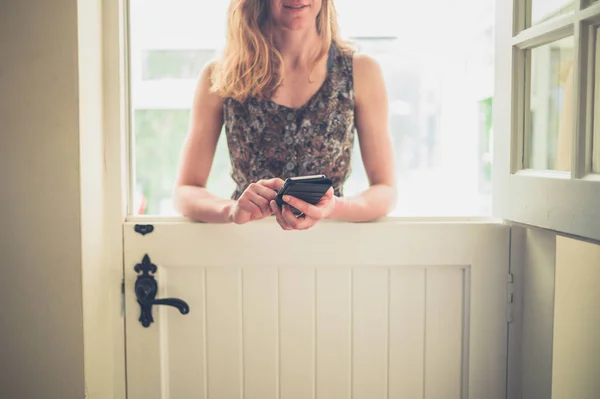 Een Jonge Vrouw Staat Door Een Stabiele Deur Gebruikt Haar — Stockfoto