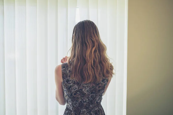 Uma Jovem Mulher Está Chegando Através Das Cortinas Casa — Fotografia de Stock