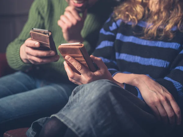 Hombre Una Mujer Están Sentados Sofá Usando Sus Teléfonos Inteligentes —  Fotos de Stock