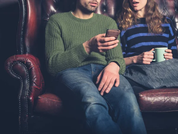 Ein Junger Mann Auf Einem Sofa Zeigt Seiner Freundin Etwas — Stockfoto