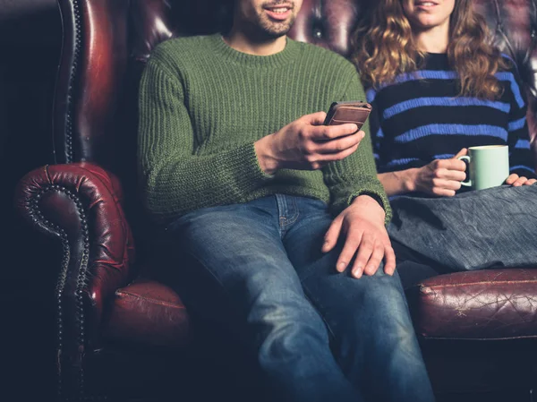 Jovem Sofá Está Mostrando Sua Namorada Algo Seu Telefone — Fotografia de Stock