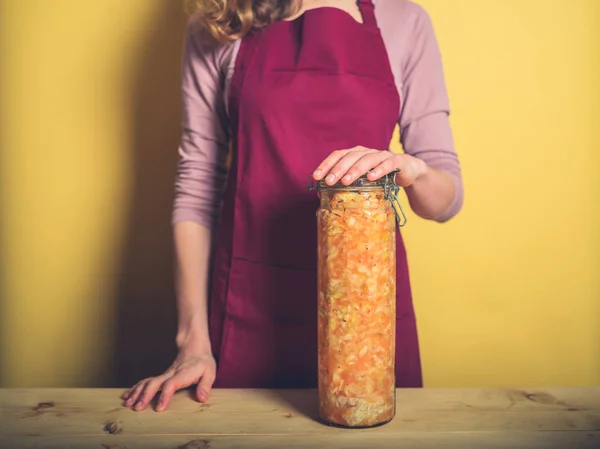 一个年轻的女人拿着一大罐超美味的自制泡菜 — 图库照片