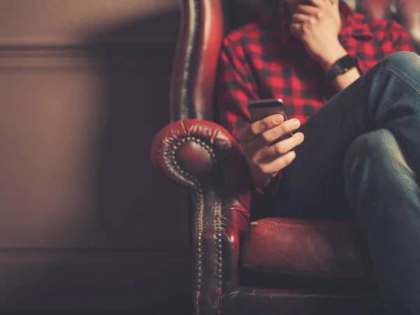 Jeune Homme Assis Sur Canapé Cuir Utilise Téléphone Intelligent — Photo