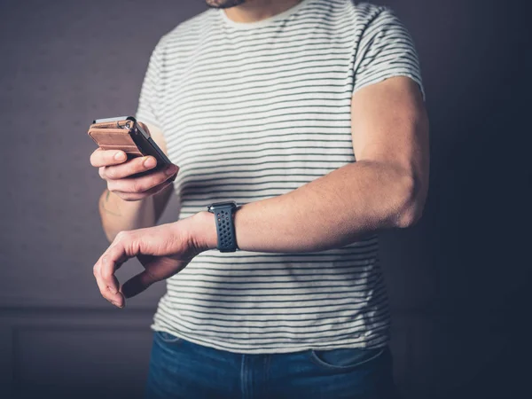 Ein Junger Mann Synchronisiert Sein Smartphone Mit Seiner Fitness Tracker — Stockfoto