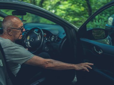 Kıdemli adam arabanın kapısını kapatıyor.