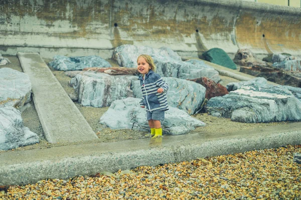 Uma Criança Pequena Está Correndo Brincando Uma Praia Rochosa Chuva — Fotografia de Stock